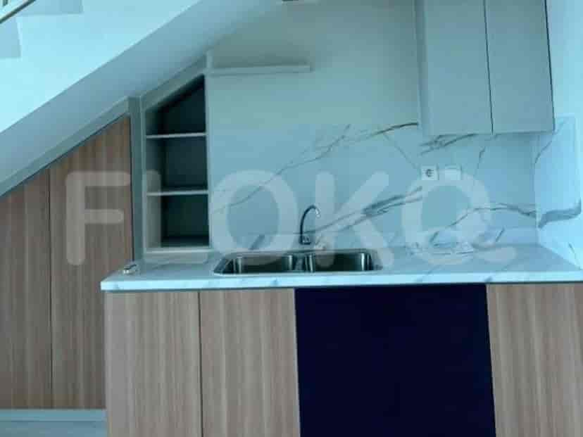 Tampilan dekat meja dapur dengan wastafel, lemari, dan backsplash marmer.