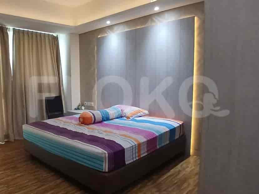 A view of a desk area with a mirror and a clothing rack in a bedroom.