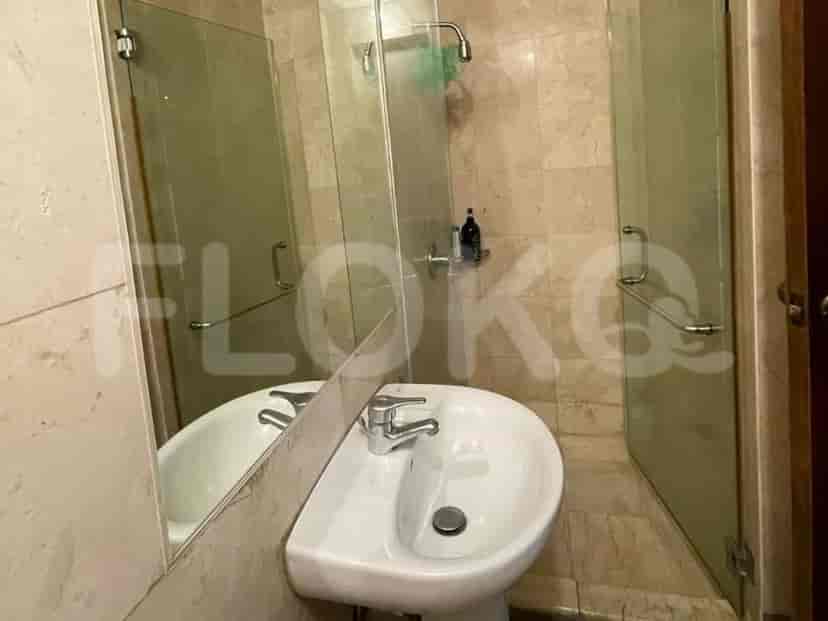A bathroom with a sink and a glass shower door.