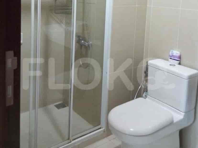 A simple bathroom with a glass shower enclosure and a toilet.