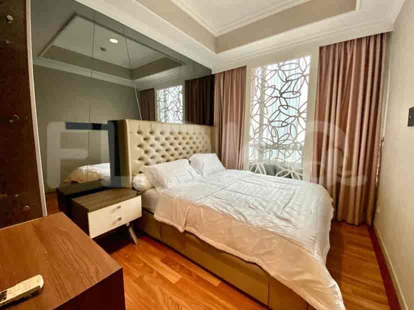 A bedroom with a king-size bed and a mirrored wall.