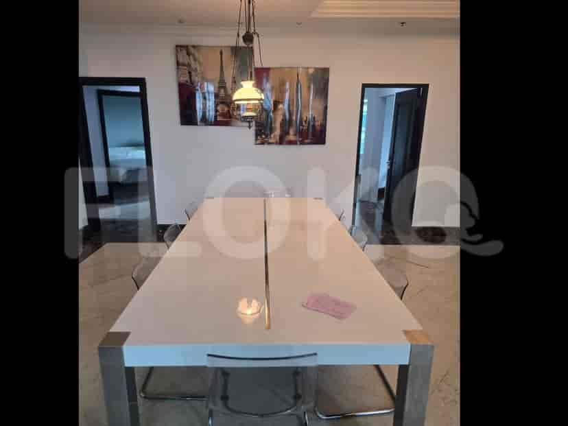 Area tamu luas dengan meja dan kursi makan, sofa, dan jendela besar.
