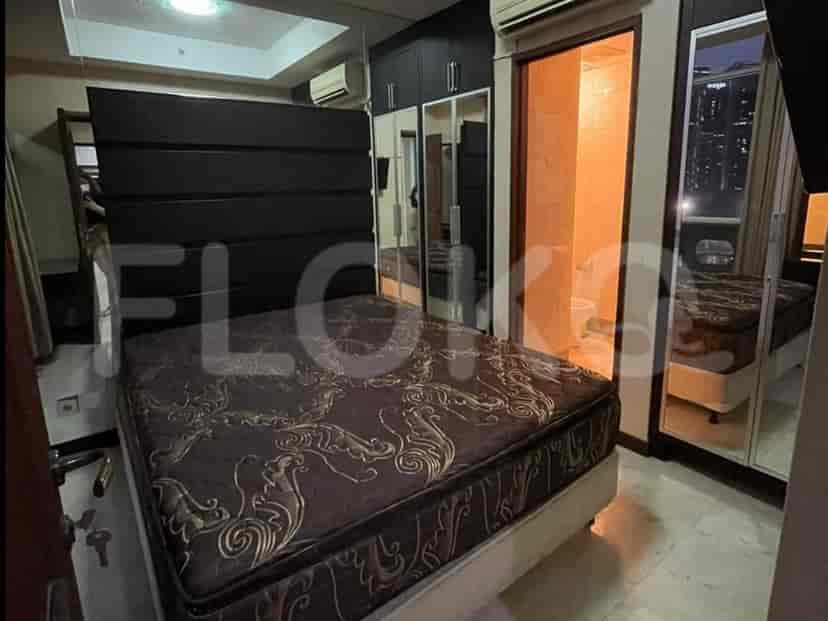 A bedroom featuring a large bed, mirrored closet doors, and a window.