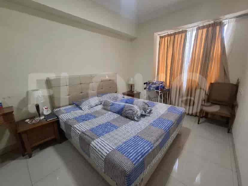 A bedroom with a large bed, nightstands, and curtains.