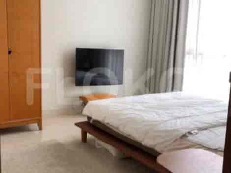 A bedroom with a bed, a wardrobe, and a wall-mounted television.