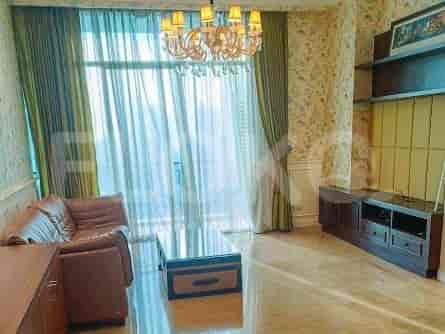 A living room with a brown leather sofa, a glass coffee table, and a TV console.