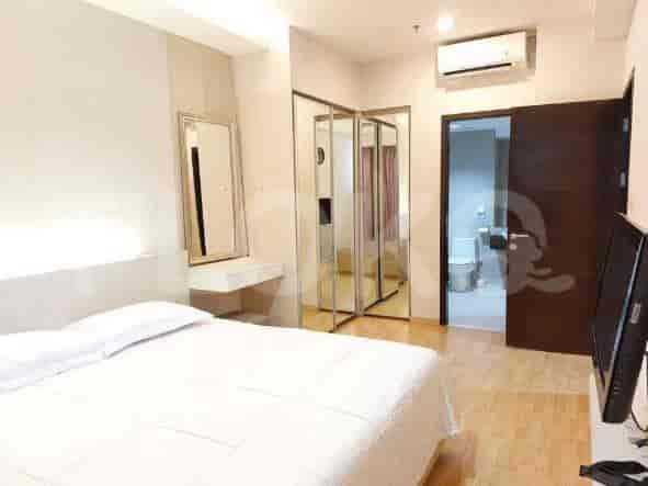 A bedroom with a bed, mirror, and an ensuite bathroom.