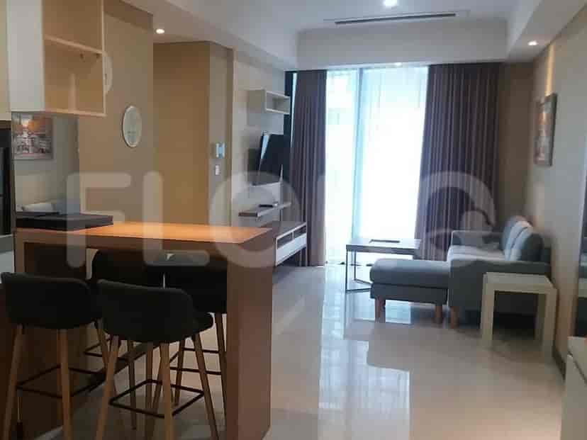 Ruang tamu modern yang menampilkan dapur dan area tempat duduk.