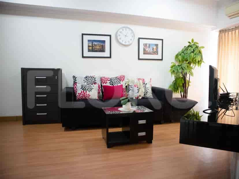 A living room with a dark sofa, coffee table, and decorative pillows.