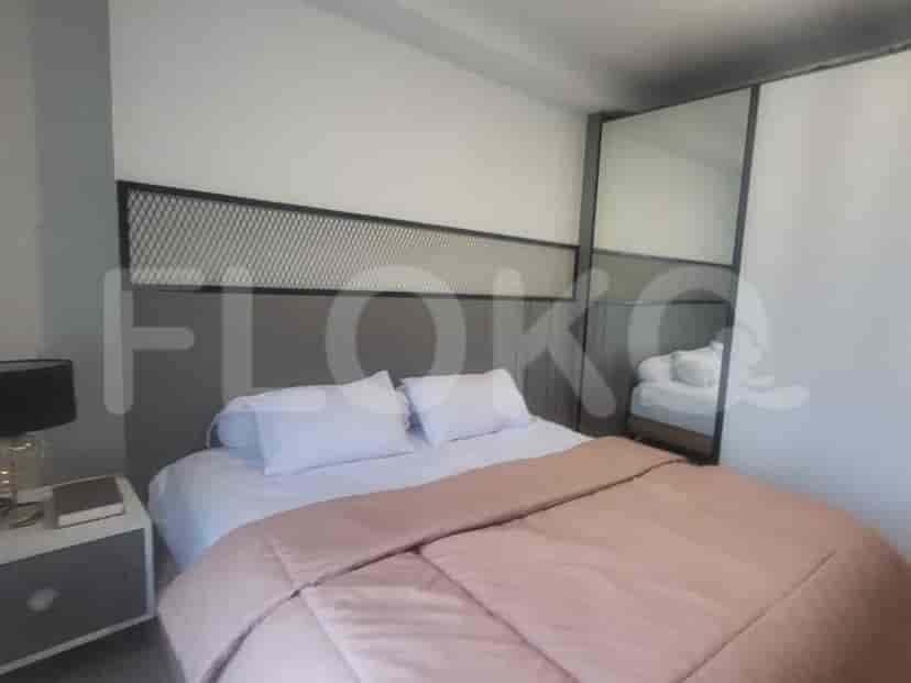 Kamar tidur modern dengan tempat tidur, cermin besar, dan palet warna netral.