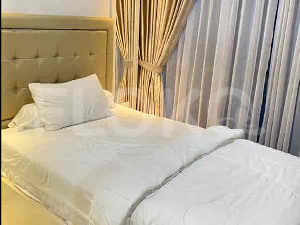A bedroom with a single bed and beige curtains.