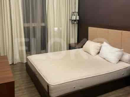 Kamar tidur dengan tempat tidur, meja samping, dan jendela dengan gorden.