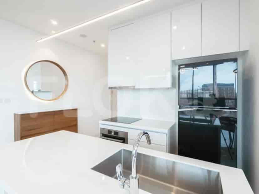 Kitchen with white cabinets, a fridge, and a cooking surface.