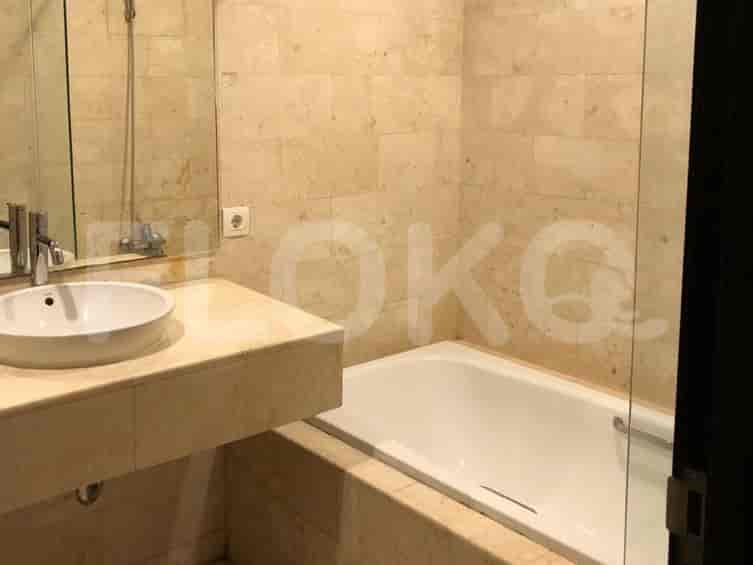 A bathroom with a bathtub, sink, and marble tiling.