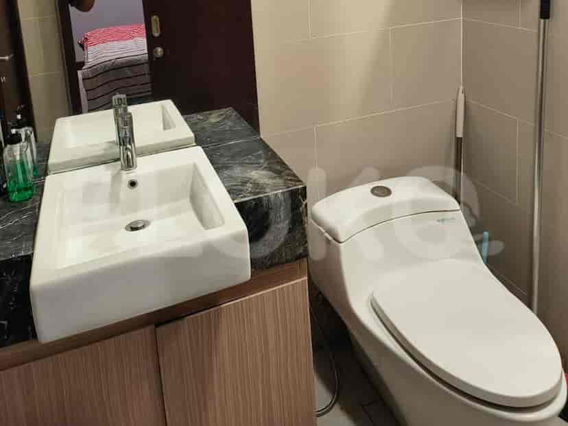 A modern bathroom featuring a wall-mounted sink, toilet, and a vanity.