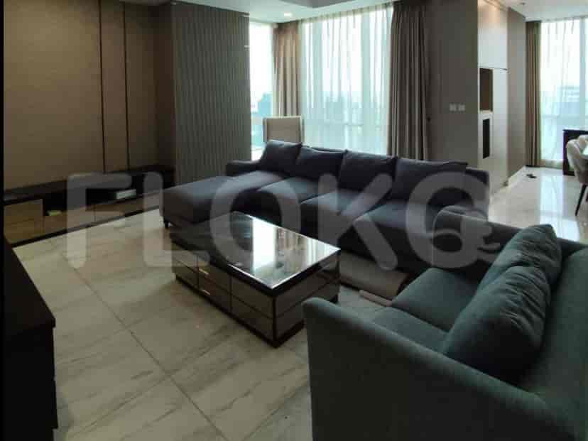 A spacious living room with an L-shaped grey sofa and glass coffee table.