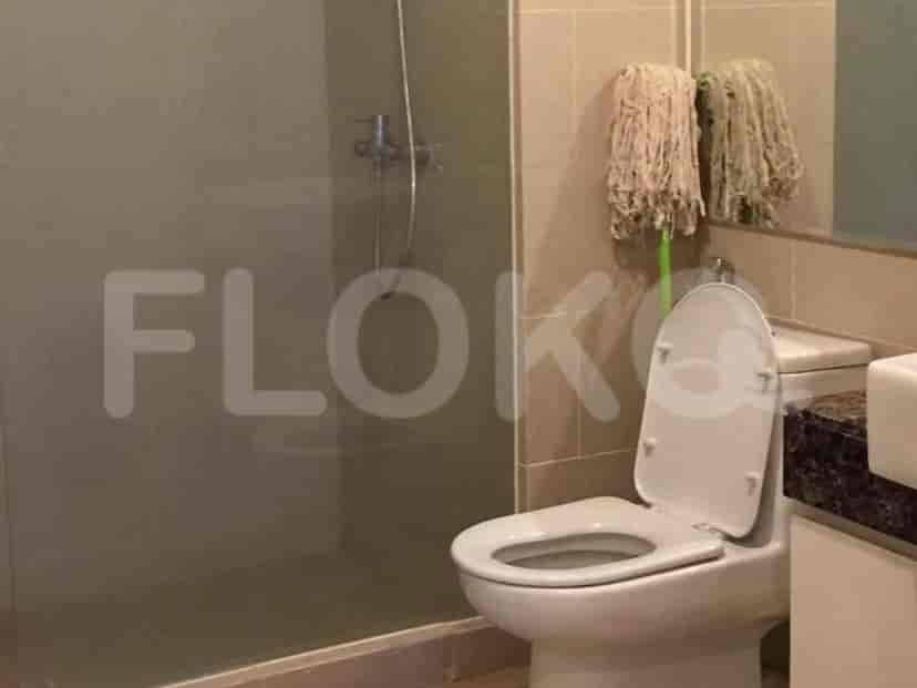 A bathroom with a toilet, shower stall, and vanity.
