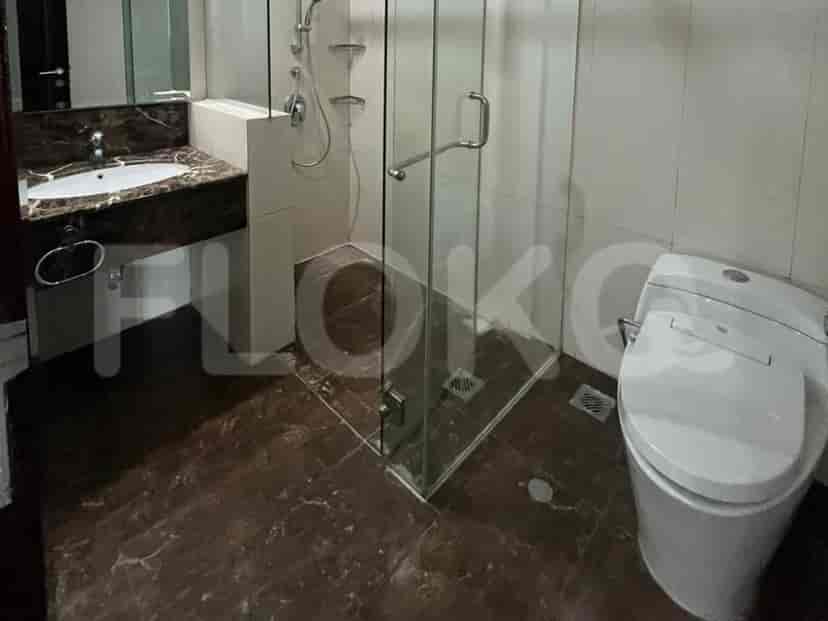 A modern bathroom with a glass shower and toilet.