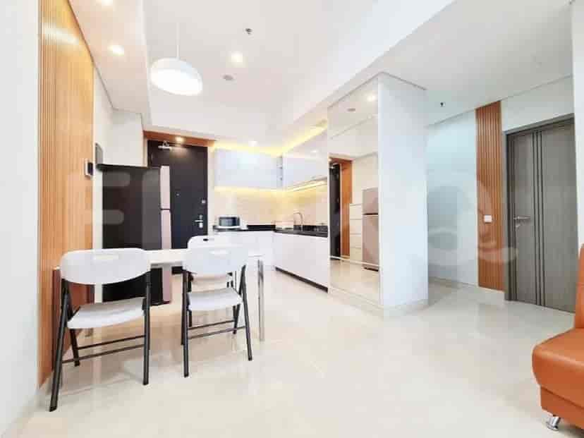 Area makan dengan meja dan kursi di samping dapur modern.