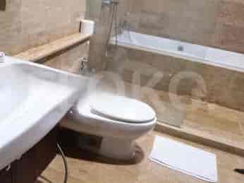 A bathroom with a bathtub, toilet, and glass shower enclosure.