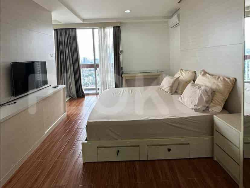 A bedroom with a queen-size bed, TV, and large window.