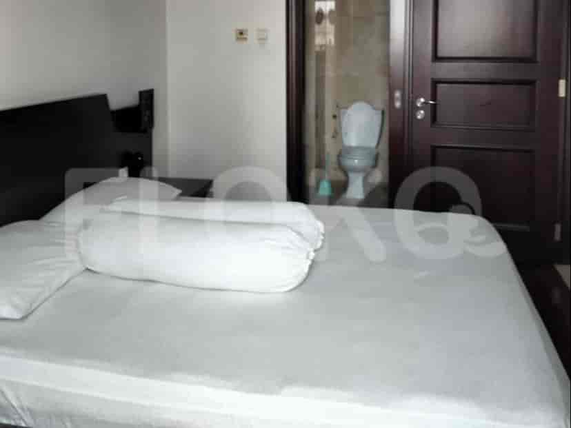Kamar tidur dengan tempat tidur, pintu kamar mandi.