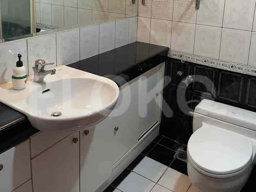 Kamar mandi dengan wastafel, cermin, dan toilet.