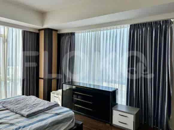 A bedroom with a black dresser, bed, and curtains.