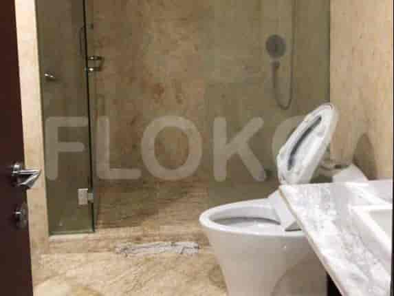 A bathroom with a toilet, shower, and glass enclosure.