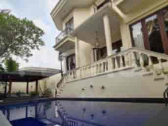 A large house with a swimming pool, a balcony, and a patio area.