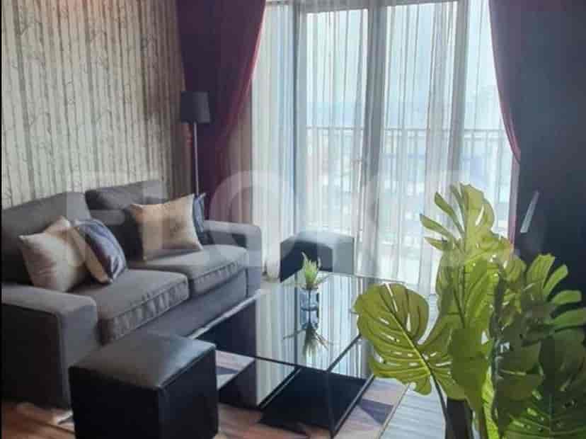A modern living room featuring a grey sofa, glass coffee table, and floor-to-ceiling windows.