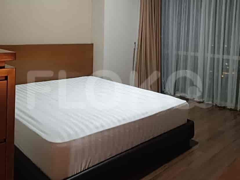 A bedroom with a queen-size bed and a wooden headboard.