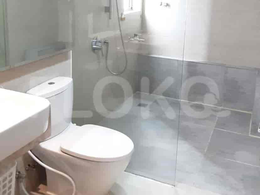 A modern bathroom with a toilet, sink, and shower area.