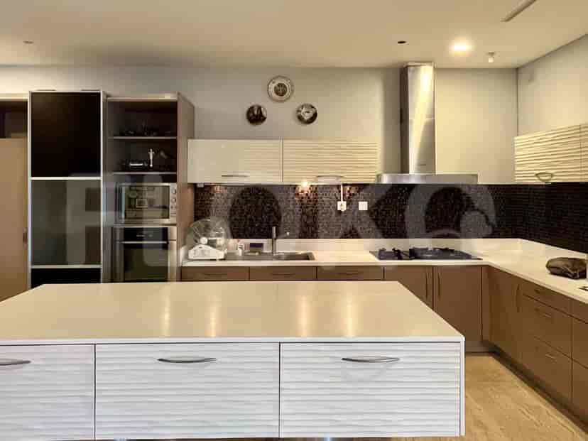 A modern kitchen with an island, countertops, cabinets, and appliances.
