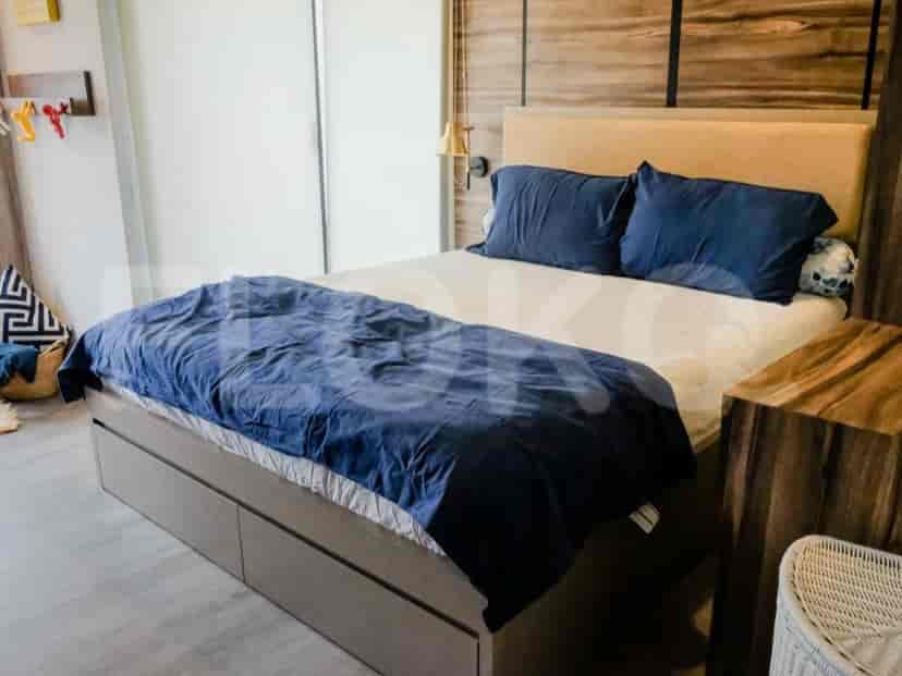 A bedroom with a bed, nightstand, and wooden wall paneling.