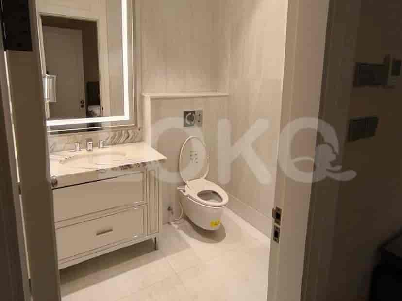 A modern bathroom featuring a vanity, toilet, and marble finishes.