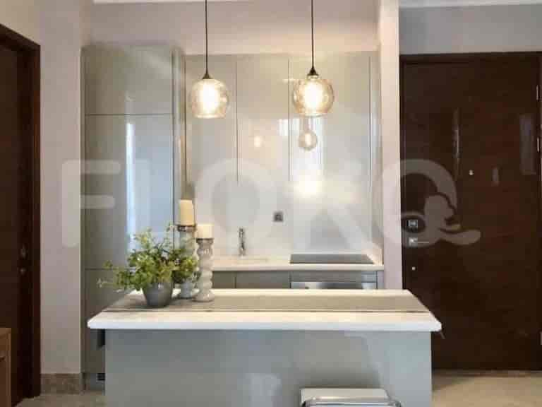 Dapur modern dengan lemari glossy, meja island, dan lampu gantung.