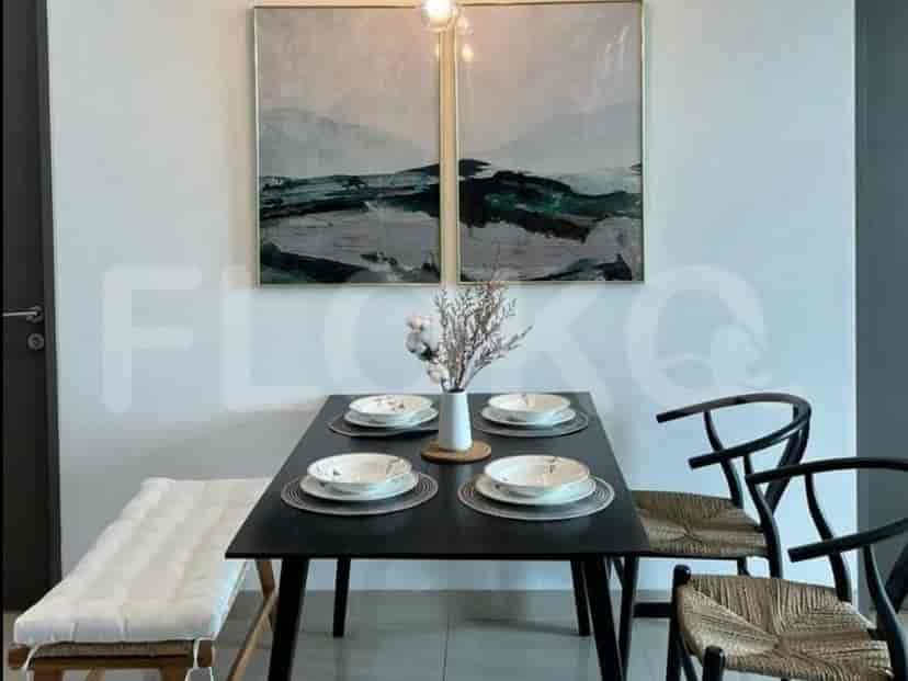 Dining area with a black table, chairs, and artwork.