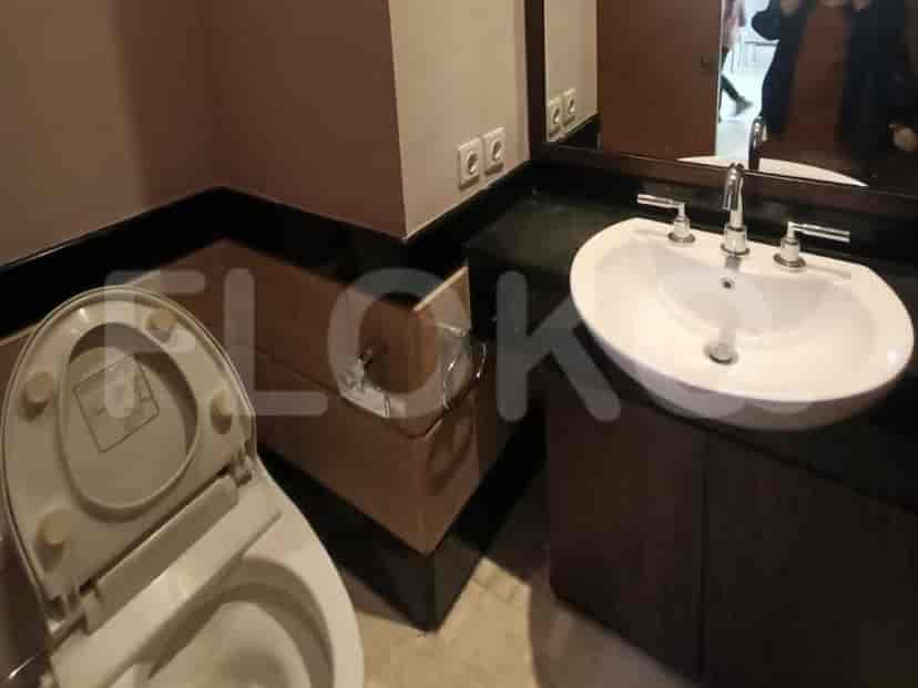 Kamar mandi dengan toilet, wastafel, dan laci.