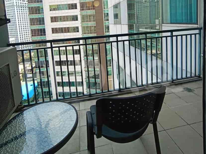 A balcony with a table and chairs, overlooking the city view.