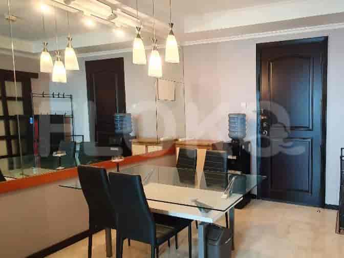 A dining area with a large mirror and a modern dining set, complemented by decorative hanging lights.