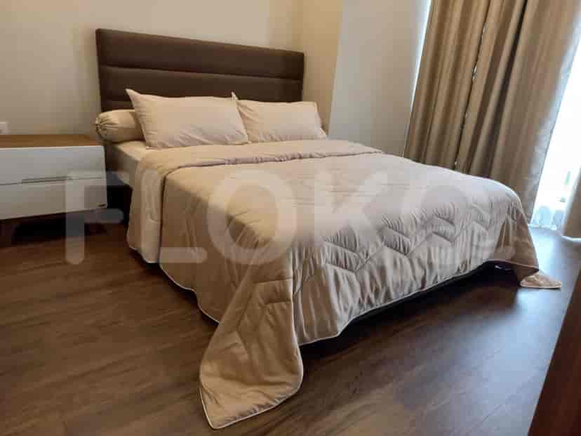 Bedroom with a large bed, side table, and window.