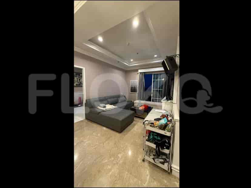 A living room with a large sectional sofa, a coffee table, and a TV mounted on the wall.