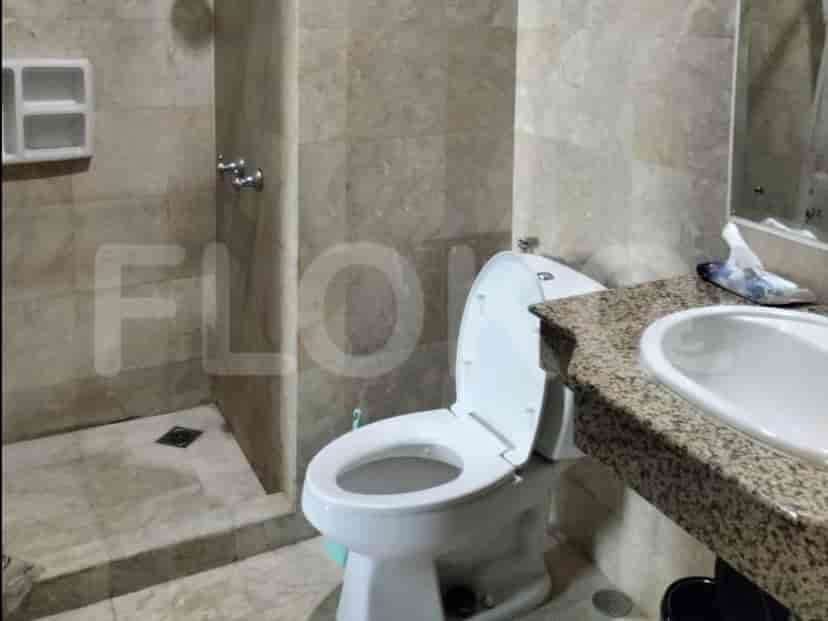 Kamar mandi yang menampilkan toilet, wastafel, dan ubin.