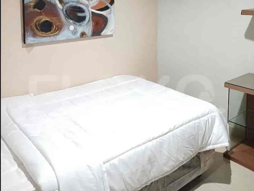A simple bedroom with a double bed and a painting.