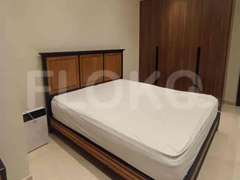 A bedroom with a bed, wooden wardrobe, and an air purifier.