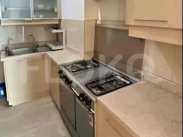 A compact kitchen with a gas stove, stainless steel sink, and light-colored cabinets.
