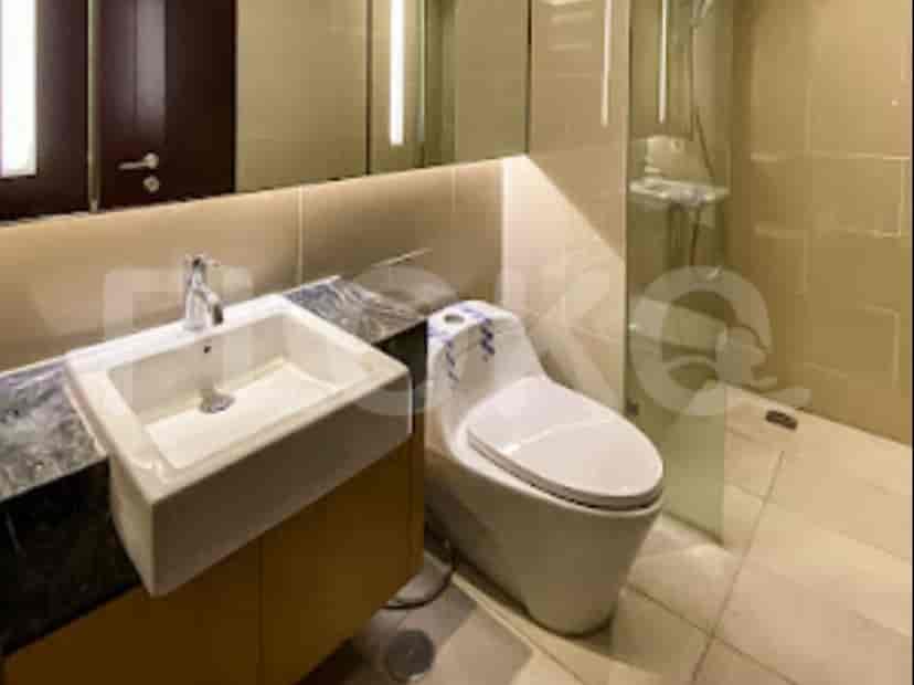 A modern bathroom with a sink, toilet, and a glass-enclosed shower.