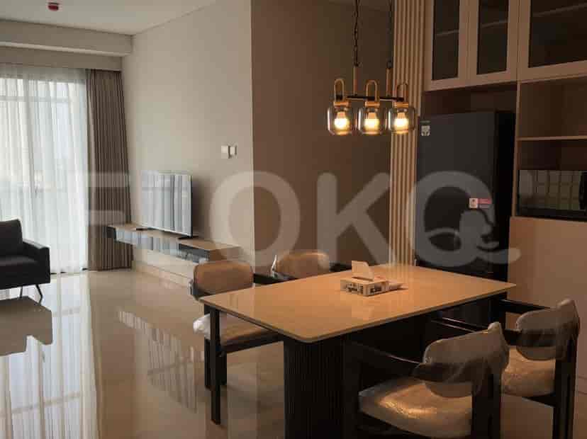 A dining area with a table, chairs, and a TV.