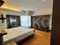 A spacious living room featuring a large TV, comfortable seating, and a scenic view.